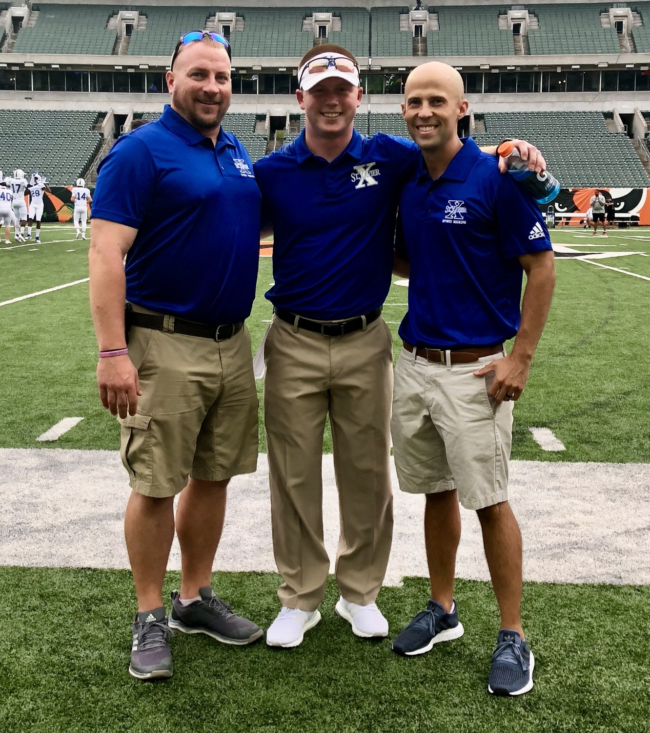 Michael Gordon with St. Xavier coaching staff on the stadium field