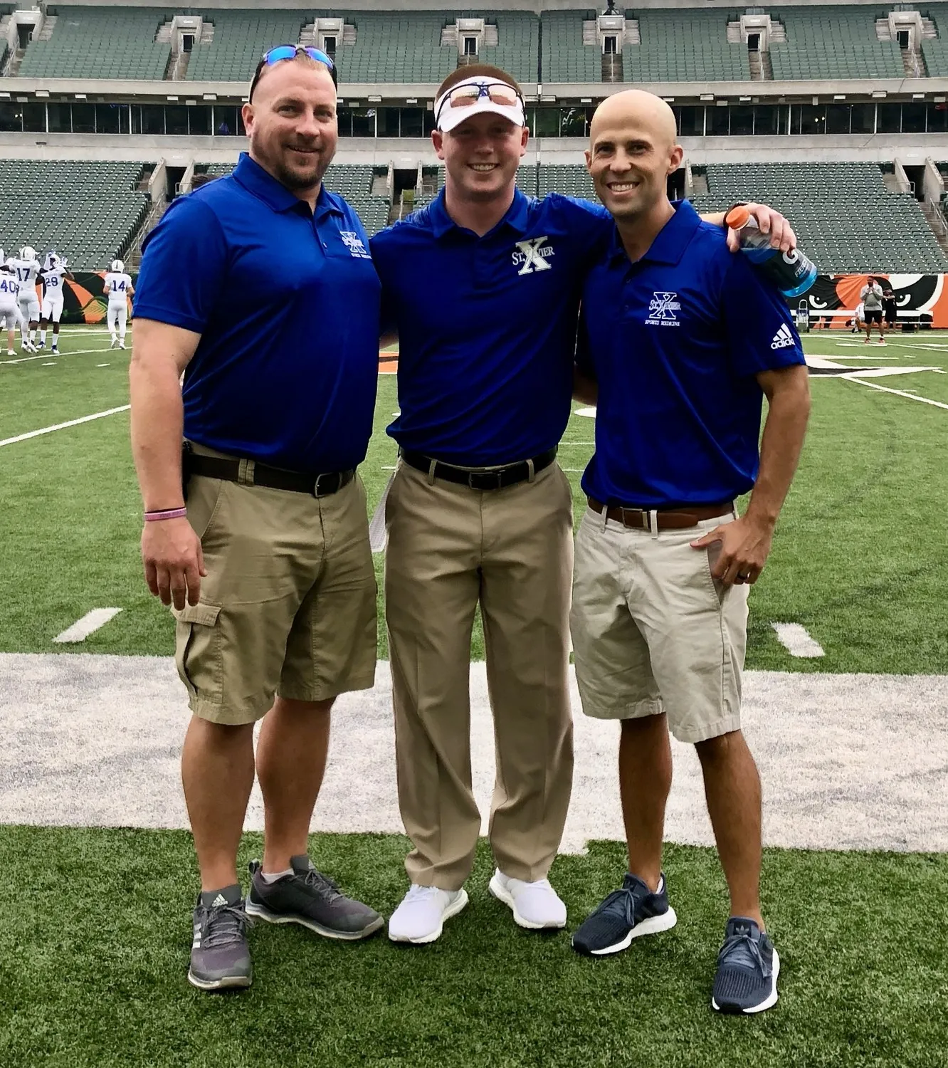 Michael Gordon with St. Xavier coaching staff on the stadium field